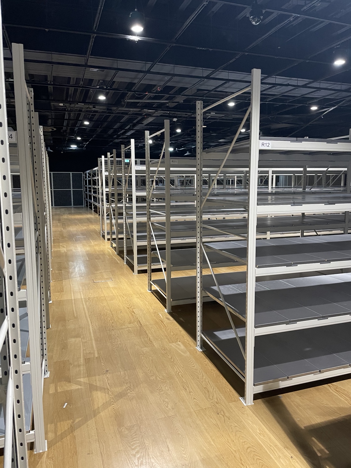Rows of static shelving with steel shelves and clear access aisles